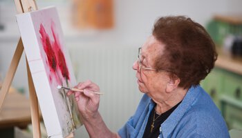 Seniorin malt ein Bild mit einem Pinsel | © Erwin Wodicka - Fotolia