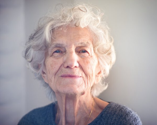 Glückliche Seniorin schaut in die Kamera | © ivanastar - gettyimages - istock
