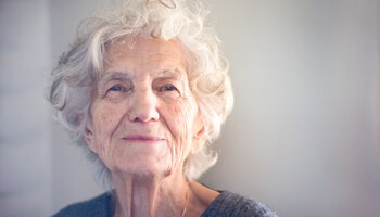 Glückliche Seniorin schaut in die Kamera | © ivanastar - gettyimages - istock