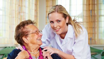Glückliche Betreuerin bei einer Seniorin | © Pressmaster XL - fotolia