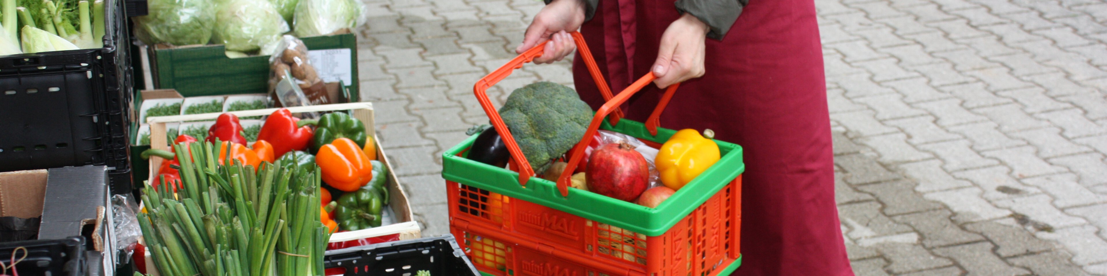 Zusammenstellung eines Gemüsekorbs an der Lebensmittelausgabe | © Caritas Oberbayern