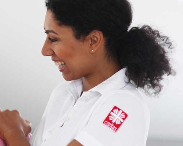 Eine Pflegerin legt eine Dame die Hand auf die Schulter | © Caritas München und Oberbayern